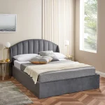 Contemporary bed with arched headboard and gold-accented side tables.