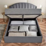Stylish bedroom setup with a grey velvet headboard and minimalist decor.